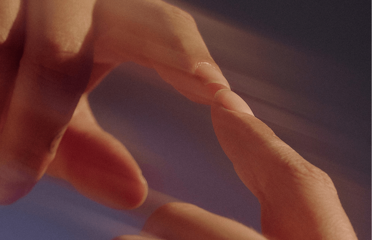 Close-up of two hands touching fingertips
